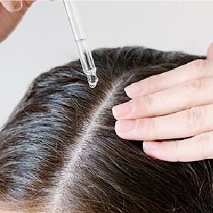 2/將頭髮分線，將青春露滴於「頭皮」上。